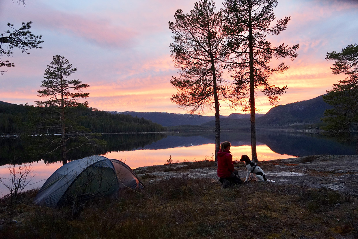 Teltplass ved vannet Nevlingen. Solnedgang med oransjefarget himmel.