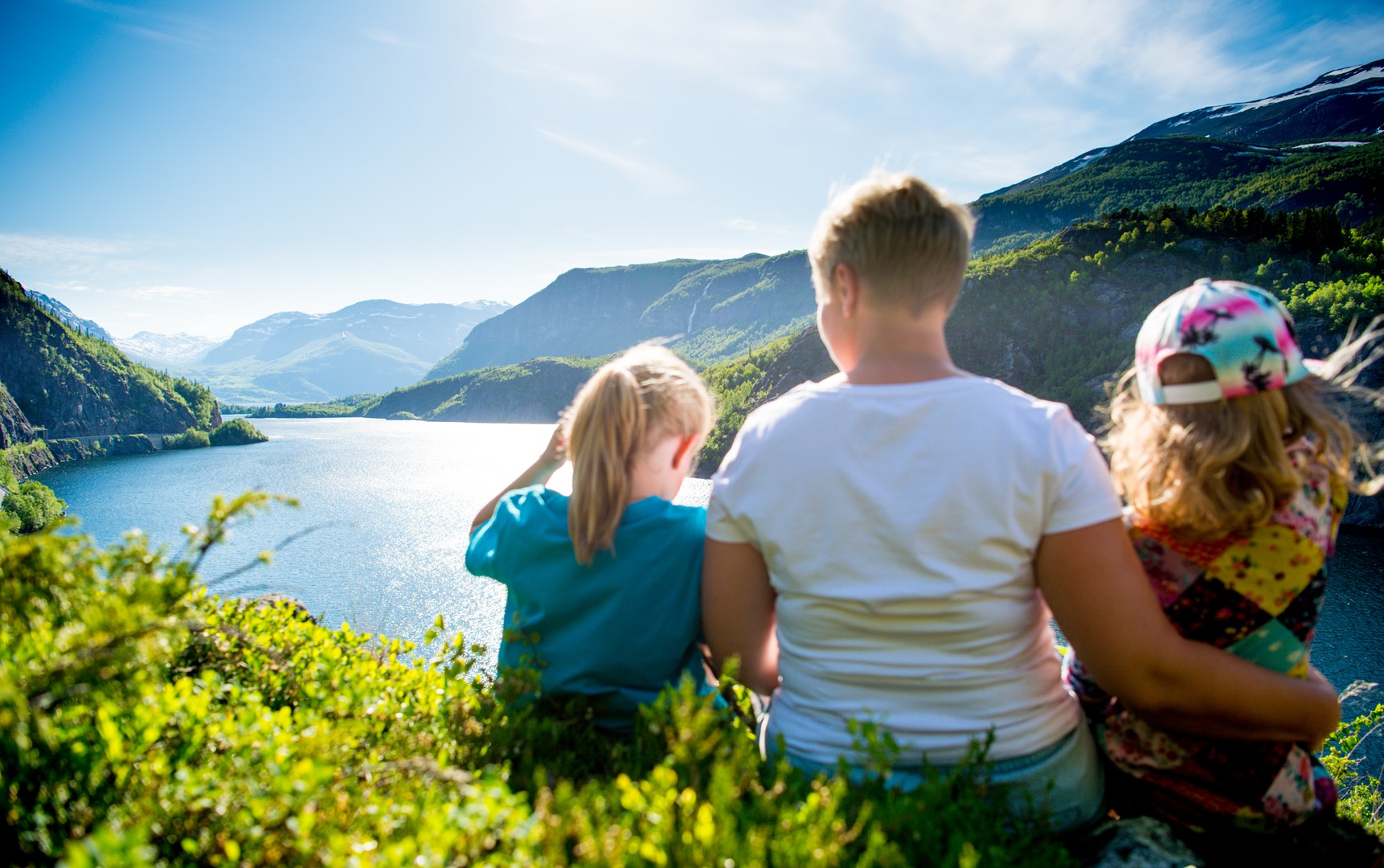 Familie som skuer utover fjell og fjord.